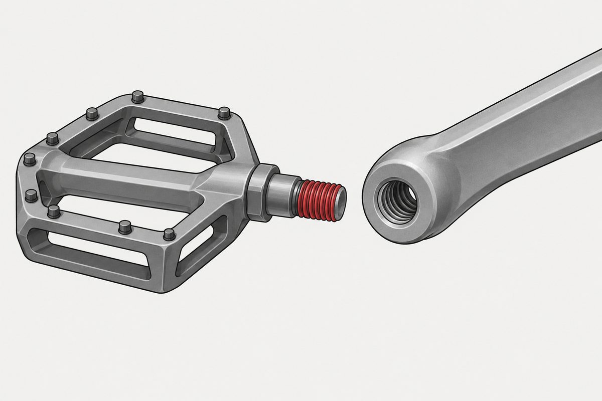 A steel-grey bicycle pedal sits apart from its crank arm, with the exposed spindle threads highlighted in red.