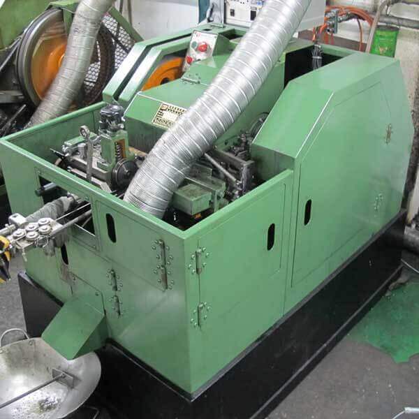 Cold heading machine with the wire feed roller set on the left